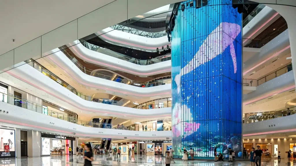 Solutions 1 Immersive Transparent LED Cylinder Screen Displaying Whale in a Luxury Retail Mall, Engineered by Adhaiwell