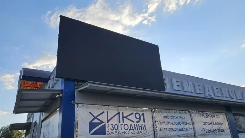 Adhaiwell outdoor LED billboard installed on a commercial building in Bulgaria, shown in the pre-commissioning stage with the black display panel against a clear sky.